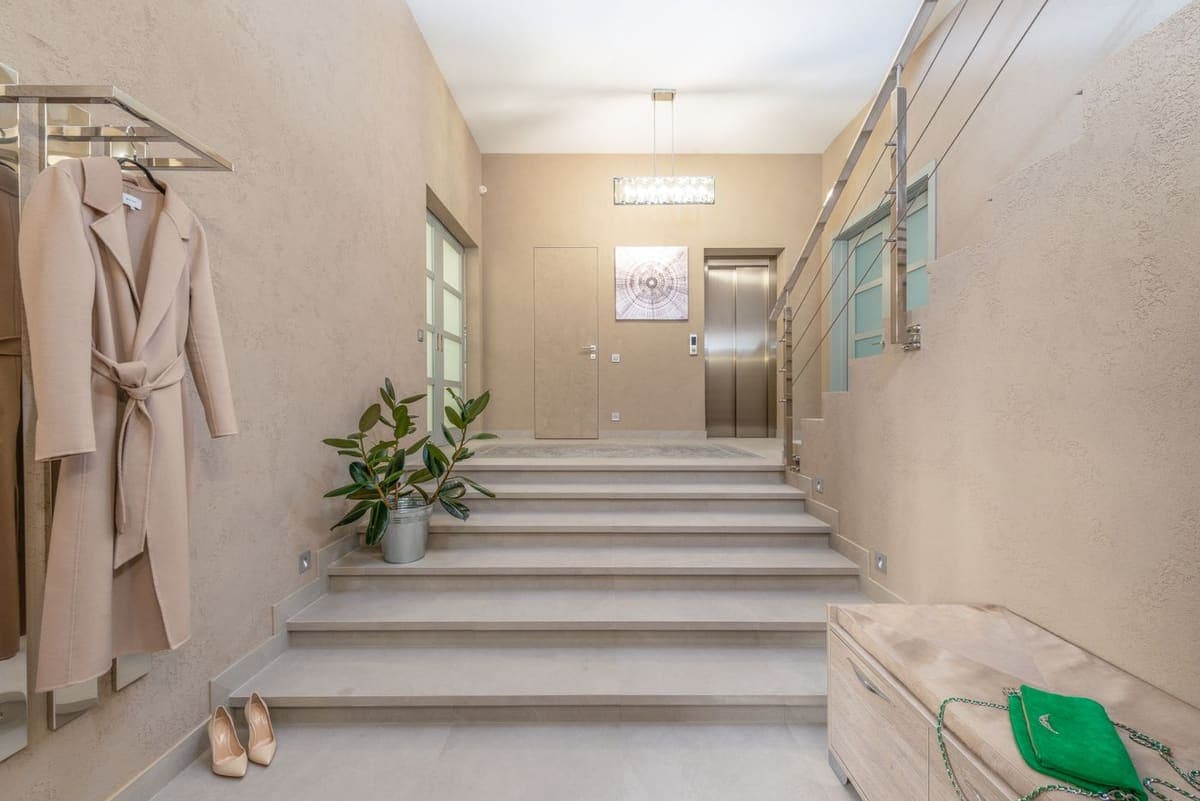 Hall d'immeuble et volée d'escalier, plantes et boîtes aux lettres