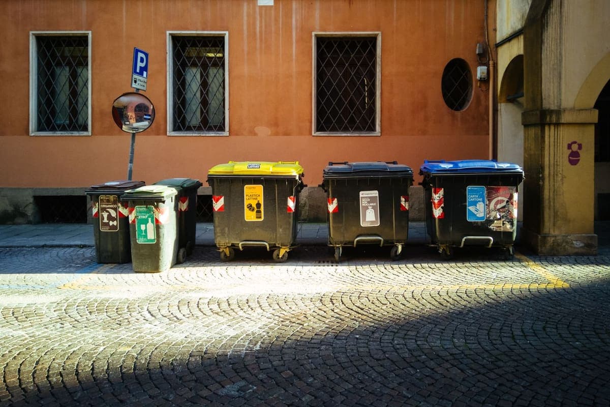 Bacs roulants de tri stationnés dans une ruelle pavée