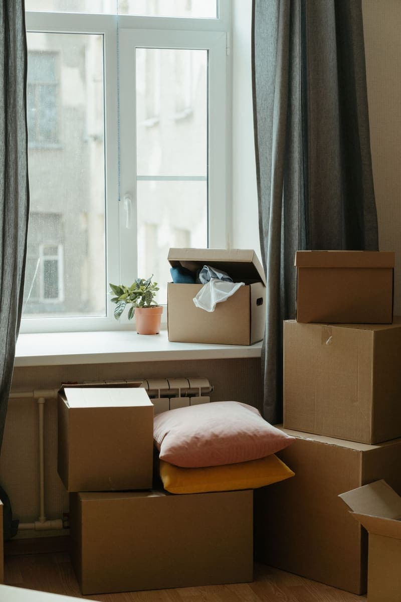 Cartons de déménagement empilés devant une fenêtre