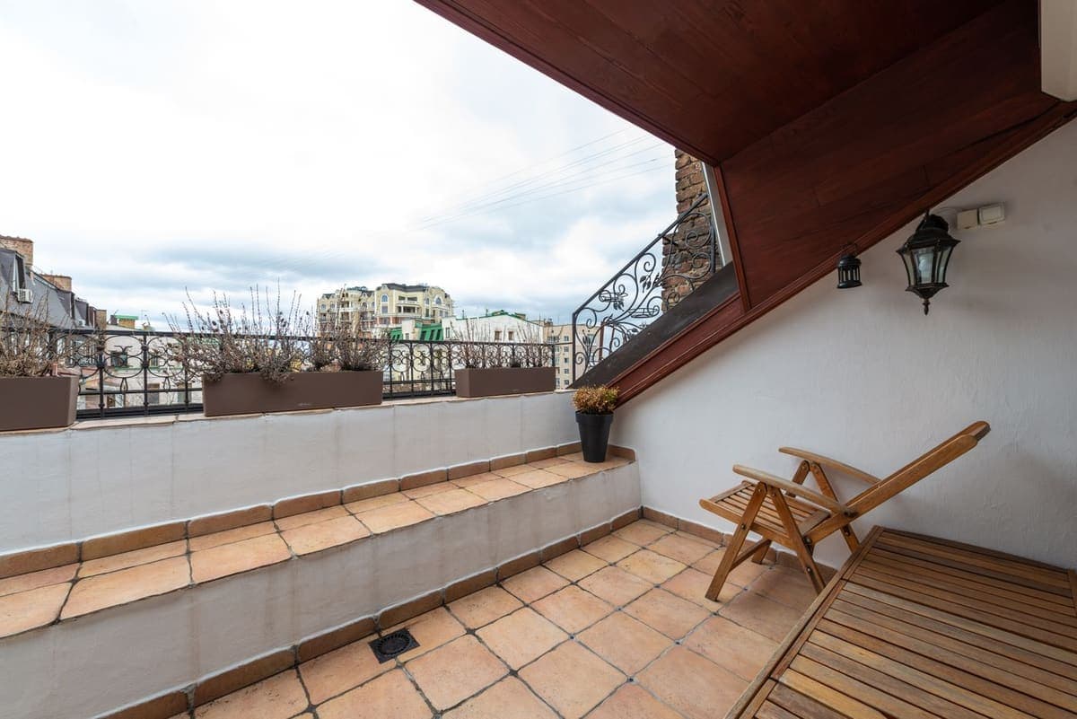 Véranda au sol carrelé ouverte sur une terrasse