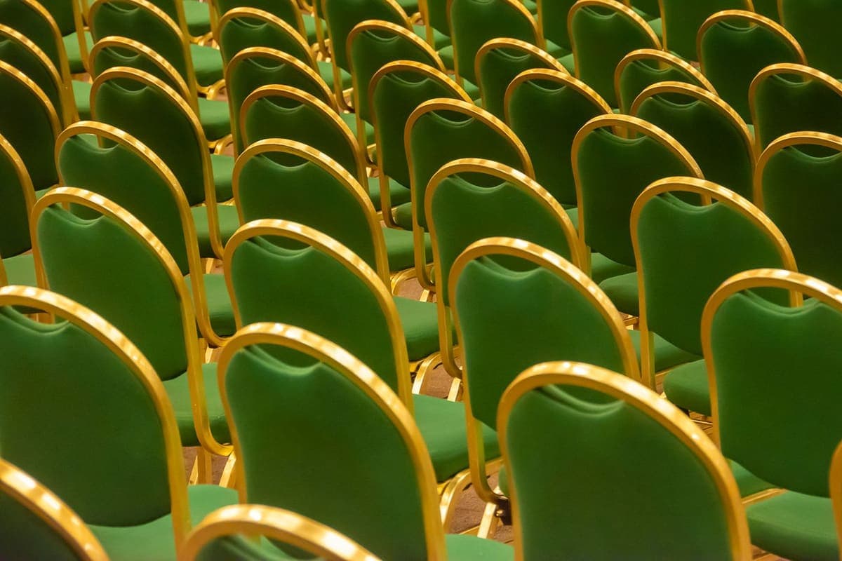Rangées de chaises alignées dans une grande salle