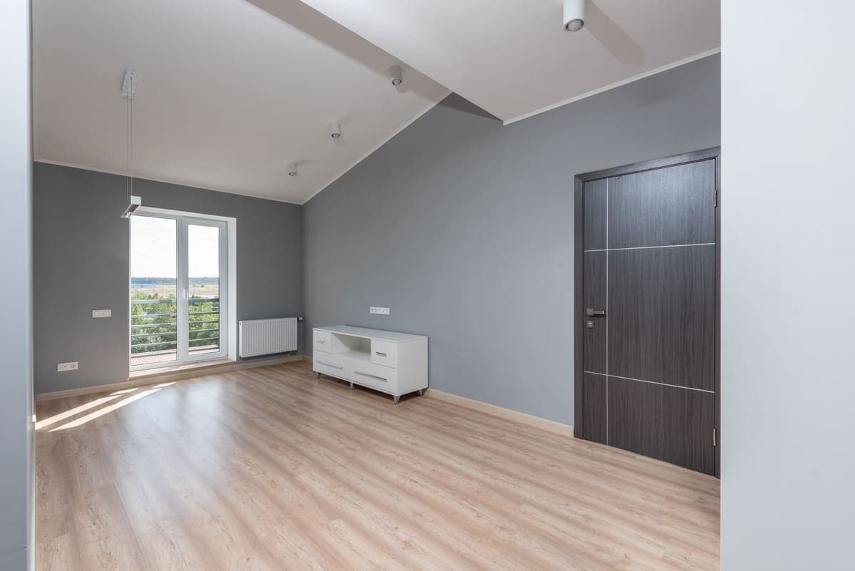 Pièce vide et aérée, parquet clair et murs repeints